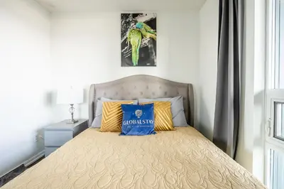 a bed with a blue pillow on top of it at Panoramic 2 Bedroom Condo with Terrace Fort York Downtown Toronto in Toronto