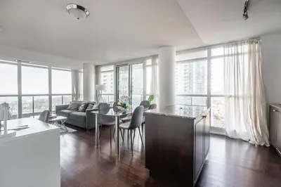 a kitchen and living room with a table and chairs at Panoramic 2 Bedroom Condo with Terrace Fort York Downtown Toronto in Toronto