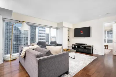 a living room with a couch and a tv at Centrally located 2 Bd 2 Bth + Parking in Toronto