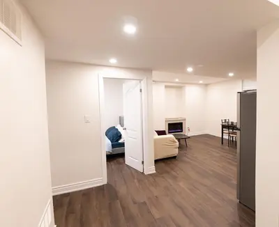 an empty living room with a couch and a television at New Basement Apartment with parking in Oakville