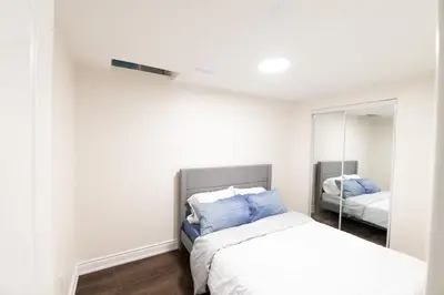 a bedroom with a bed and a mirror at New Basement Apartment with parking in Oakville