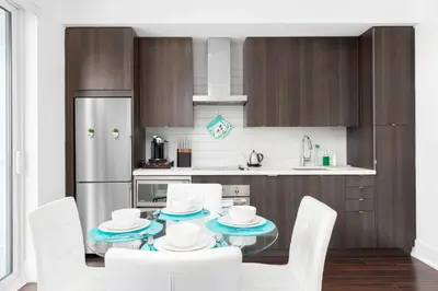 a kitchen with a table with white chairs and a refrigerator at Apartament Downtown Toronto + Beautiful View in Toronto