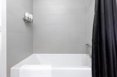 a white bathroom with a tub and a shower curtain at Apartament Downtown Toronto + Beautiful View in Toronto
