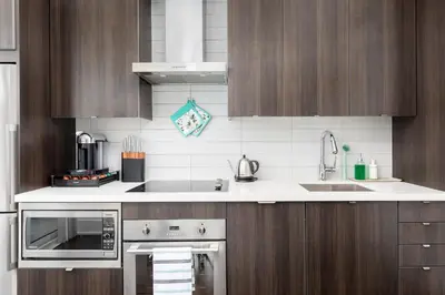 a kitchen with wooden cabinets and a stainless steel oven at Apartament Downtown Toronto + Beautiful View in Toronto