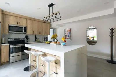 a kitchen with a large white island with bar stools at Urban Oasis Steps to UofT Culture Patio in Toronto