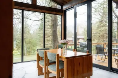 a dining room with a table and chairs and large windows at Stunning Lakeview Muskoka Pier 100 Resort in Port Carling