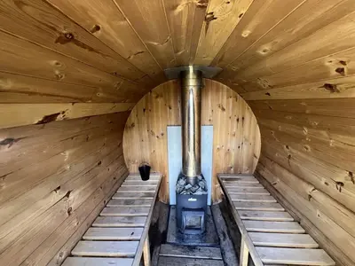 an inside of a wooden sauna with a stove at Stunning Lakeview Muskoka Pier 100 Resort in Port Carling