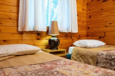 a bedroom with two beds and a lamp on a table at Stunning Lakeview Muskoka Pier 100 Resort in Port Carling