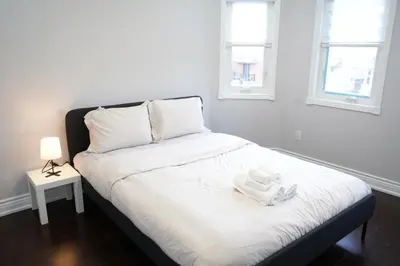 a bed with two white towels on it in a room at Large Family Favorite Spacious 6-Bedroom Home in Brampton