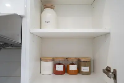 a shelf with four jars of spices in a kitchen at Large Family Favorite Spacious 6-Bedroom Home in Brampton