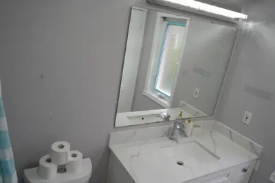 a white bathroom with a sink and a mirror at Large Family Favorite Spacious 6-Bedroom Home in Brampton