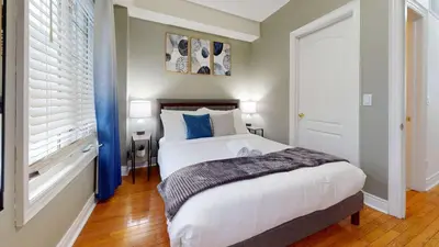a bedroom with a bed with white sheets and blue pillows at Modern & Spacious Midtown Toronto Family Home in Toronto