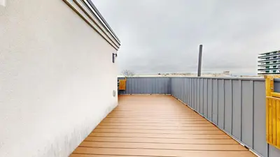 a balcony with a white wall and a wooden walkway at Modern & Spacious Midtown Toronto Family Home in Toronto