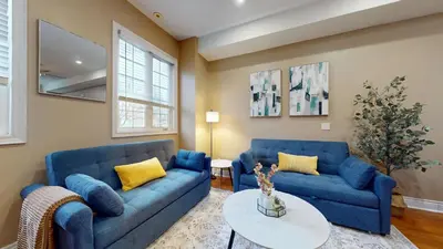 a living room with two blue couches and a table at Modern & Spacious Midtown Toronto Family Home in Toronto