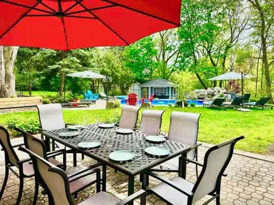 a black table with chairs and a red umbrella at The Serenity Home Pool/Yoga/Game Room by the Lake in Mississauga