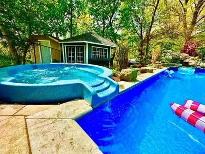 a large swimming pool with a blue tub in a yard at The Serenity Home Pool/Yoga/Game Room by the Lake in Mississauga