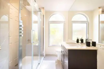a bathroom with a shower and a sink and a toilet at The Serenity Home Pool/Yoga/Game Room by the Lake in Mississauga