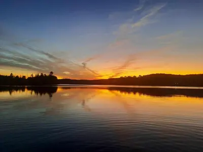 a sunset over a large body of water at Amazing Lakefront cottage on Paradise Lake in Haliburton