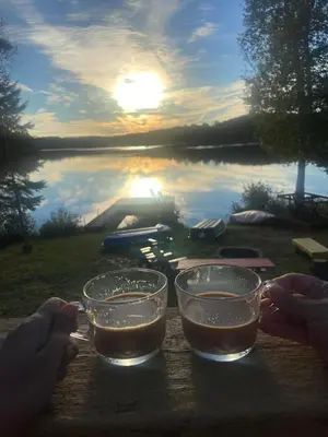 two glasses on a table with a view of a lake at Amazing Lakefront cottage on Paradise Lake in Haliburton