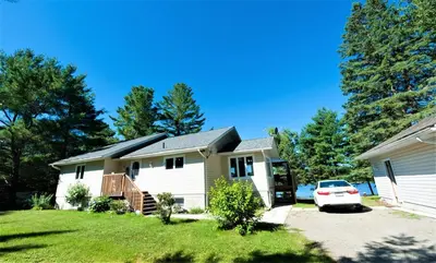 a house with a car parked in front of it at Amazing Lakefront cottage on Paradise Lake in Haliburton
