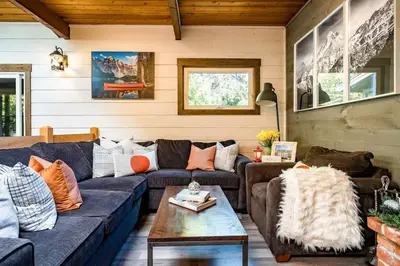 a living room with a blue couch and a table at Cozy upgraded Chalet Hot Tubs Sauna Fireplace in Blue Mountains