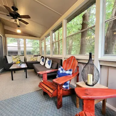 a screened in porch with chairs and a couch at Cozy upgraded Chalet Hot Tubs Sauna Fireplace in Blue Mountains