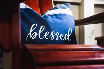 a blue pillow with the word blessed sitting on a bench at Cozy upgraded Chalet Hot Tubs Sauna Fireplace in Blue Mountains