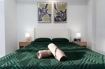 a bedroom with a green bed with two towels on it at Elegant Five Bedroom Home Designed for Comfort and Space in Oakville