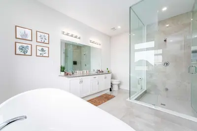 a white bathroom with a shower and a toilet at Elegant Five Bedroom Home Designed for Comfort and Space in Oakville