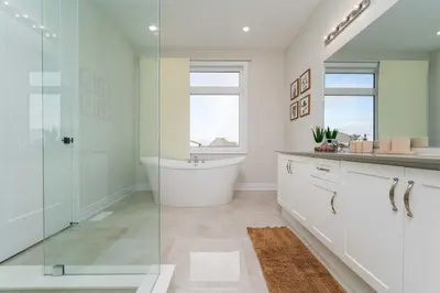 a bathroom with a tub and a glass shower at Elegant Five Bedroom Home Designed for Comfort and Space in Oakville