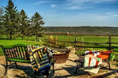 two benches with a blanket sitting next to a fence at Beaver Valley Farmhouse with Pool & Stunning Views in Kimberley