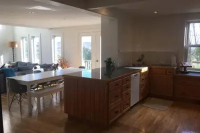a large kitchen with a table and a living room at Beaver Valley Farmhouse with Pool & Stunning Views in Kimberley