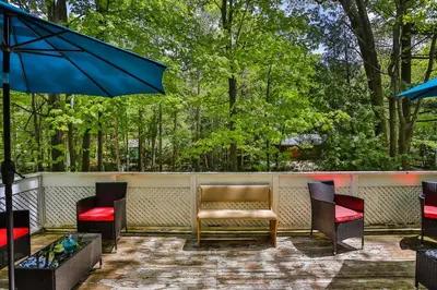 a patio with chairs and a bench and an umbrella at Cozy Georgian Bay Cottage Firepit, Beach, 4-Season in Tiny
