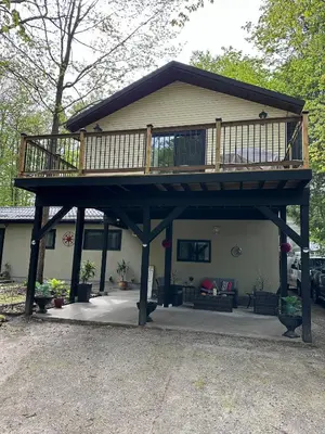 a house with a deck on top of it at Cozy Georgian Bay Cottage Firepit, Beach, 4-Season in Tiny