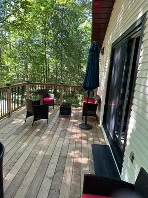 a deck with chairs and a table and an umbrella at Cozy Georgian Bay Cottage Firepit, Beach, 4-Season in Tiny