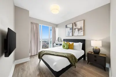 a bedroom with a bed and a large window at Modern City Condo with Parking Walk to CN Tower in Toronto