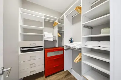 a walk in closet with white cabinets and red drawers at Modern City Condo with Parking Walk to CN Tower in Toronto