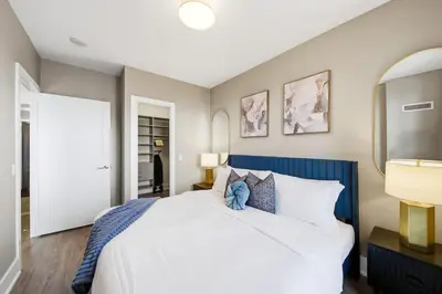 a bedroom with a large bed with a blue headboard at Modern City Condo with Parking Walk to CN Tower in Toronto