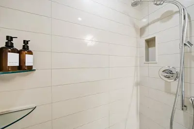 a bathroom with a shower with bottles of wine at Modern City Condo with Parking Walk to CN Tower in Toronto
