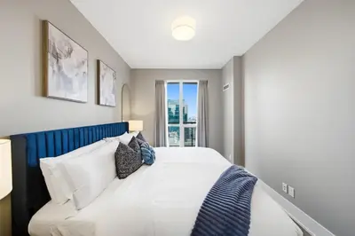 a bedroom with a white bed with a blue headboard at Modern City Condo with Parking Walk to CN Tower in Toronto