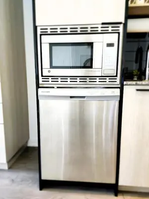 a microwave oven sitting on top of a dishwasher at Toronto Lakeview by TMU & UofT with Pool, Gym & Parking in Toronto