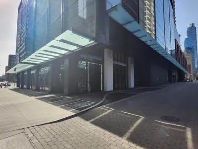 a building with a large glass building with a sidewalk at Toronto Lakeview by TMU & UofT with Pool, Gym & Parking in Toronto
