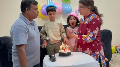 a family standing in front of a birthday cake with candles at Luxury room at southern Guelph in Guelph