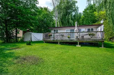 a large yard with a house with a deck at Rice Lake Retreat 2 Bed Home 16 Ft Swim spa Sauna in Bailieboro