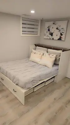 a large white bed in a room with wooden floors at Cozy East Hill 2026 in Belleville