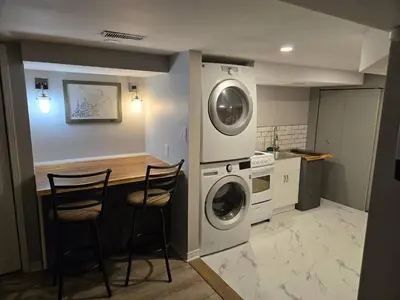 a kitchen with a washer and dryer and two chairs at Cozy East Hill 2026 in Belleville