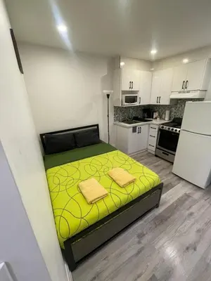 a small bedroom with a yellow bed in a kitchen at DOWNTOWN-BMO Field Stay-Next to Transit-Restaurants-Union Station in Toronto