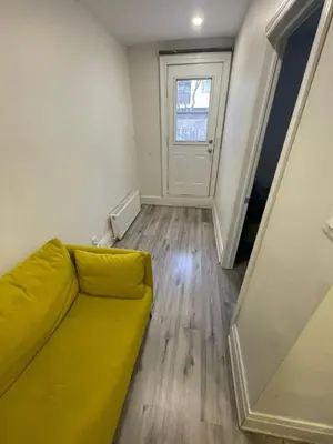 a living room with a yellow couch and a window at DOWNTOWN-BMO Field Stay-Next to Transit-Restaurants-Union Station in Toronto