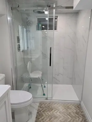 a bathroom with a shower with a chair and a toilet at Charming Streetsville 2 Bedroom Suite with Parking and Laundry in Mississauga