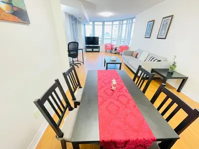 a living room with a table with a red table cloth at 2 Bedroom Luxury Suite Across Square One in Mississauga